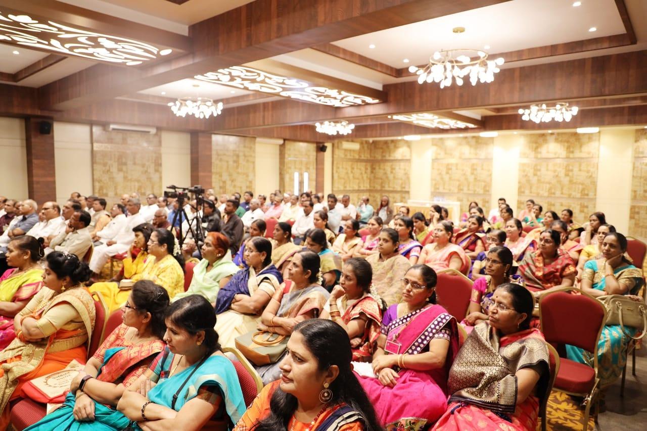 A large audience, predominantly women in traditional attire, attending a motivational session.